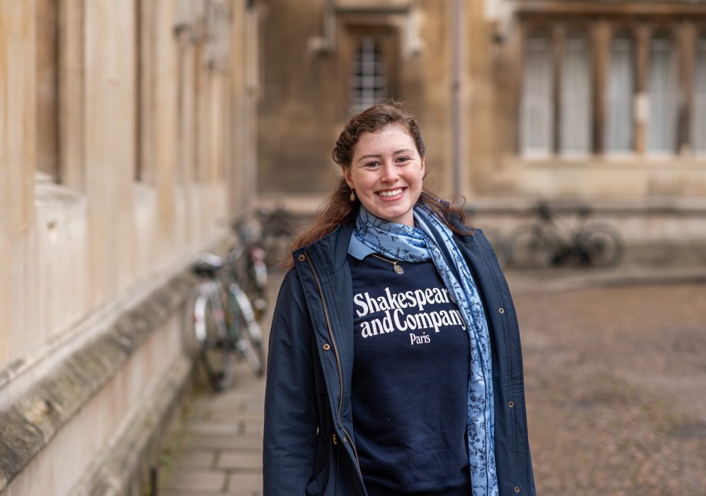 A Greene's College Oxford student smiling on an Oxford street lined with bicycles