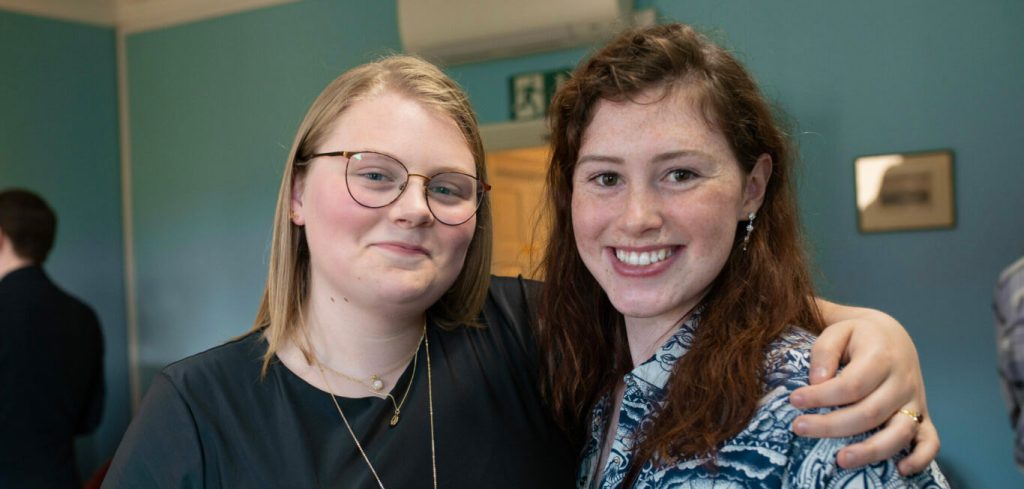 Two Greene's College Oxford students smiling together at a college social event